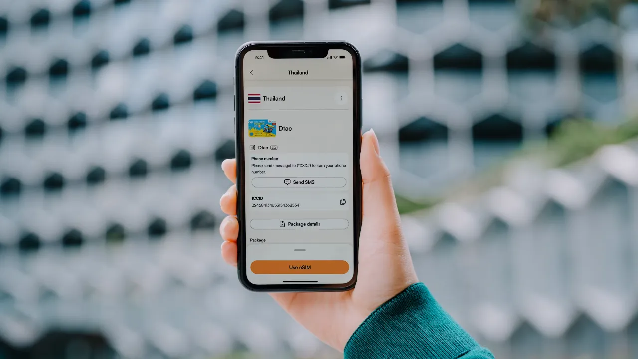 A hand holding a phone showing the Airalo app, with a travel eSIM installed and ready to use.